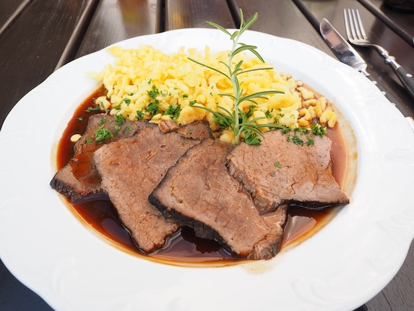 bord met Sauerbraten uit de Eifel. Aardappels, vlees in saus en kruiden